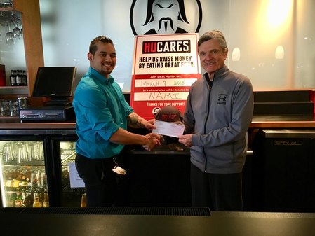 Jack Rose accepts a check from Sean Hayes, assistant manager of HuHot.